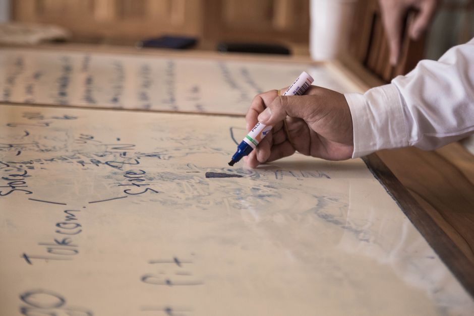 Founder and growth marketer discussing brand messaging and customer insights over printed notes in a meeting room